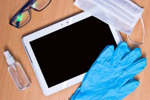 Tablet with rubber gloves test tubes and face mask top view. The concept of m Stock Photos