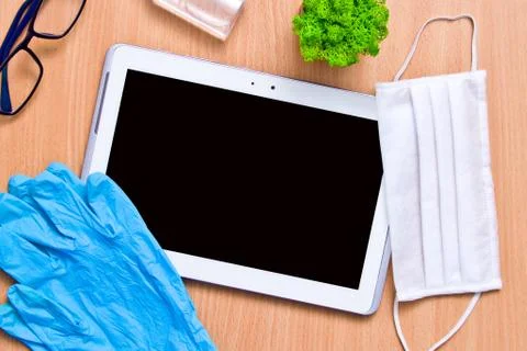 Tablet with rubber gloves test tubes and face mask top view. The concept of m Stock Photos