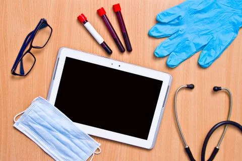 Tablet with rubber gloves test tubes and face mask top view. The concept of m Stock Photos