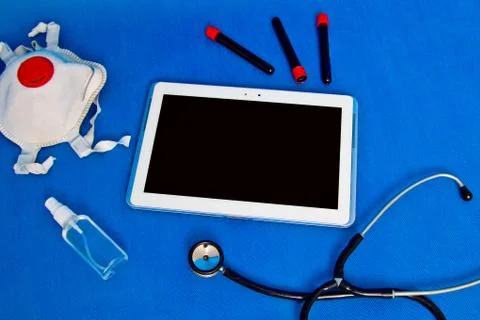 Tablet with rubber gloves test tubes and face mask top view. The concept of m Stock Photos
