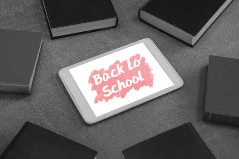 Tablet on a school table with back to school text on screen Stock Photos