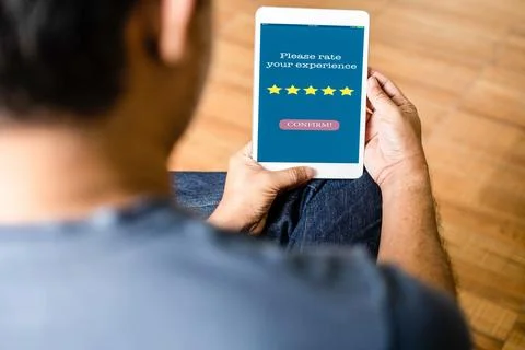 Tablet screen displays a Please rate your experience message to confirm Servi Stock Photos