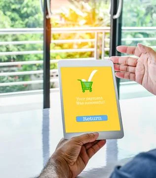 The tablet screen displays a Your payment Was successful message to confirm.. Foto stock