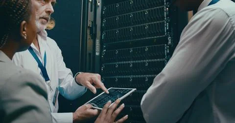 Tablet screen, server room and people in discussion for code or system Foto stock