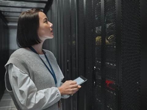 Tablet, server room and big data with a programmer asian woman at work on a Foto stock