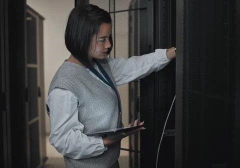 Tablet, server room and engineering with a programmer asian woman at work on a Stock Photos