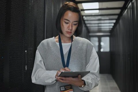 Tablet, server room and networking with a programmer asian woman at work on a 库存照片