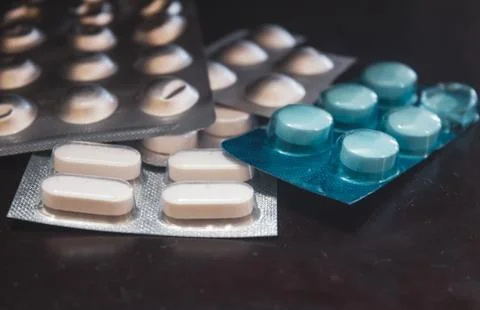 Tablet strips over one another against dark background Foto stock