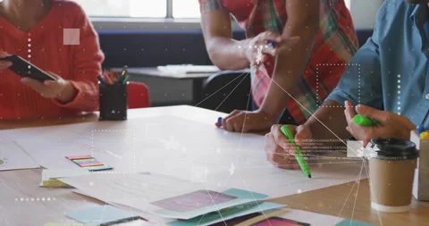Tablet tapping initiating design team sketching wireframes on paper with markers Stock Footage 315541234