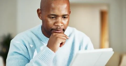 Tablet, thinking and black man in home with remote work for research on fro.. Stock Photos