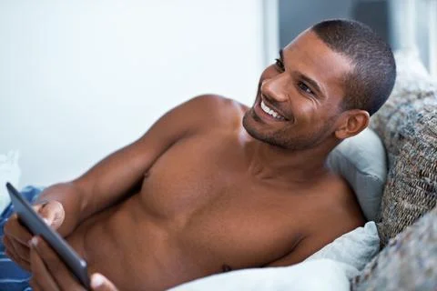 Tablet, thinking and man in bed at house for texting, social media or connection Stock Photos