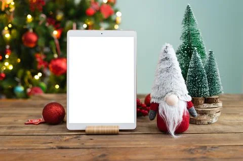 Tablet in vertical with blank screen for mockup. Wooden table with tablet. Stock Photos