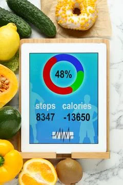 Tablet with weight loss calculator application and food products on white m.. 写真素材
