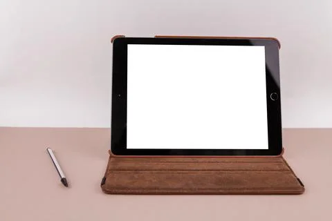 Tablet with white screen on the office table and a stylus pen near Stock Photos