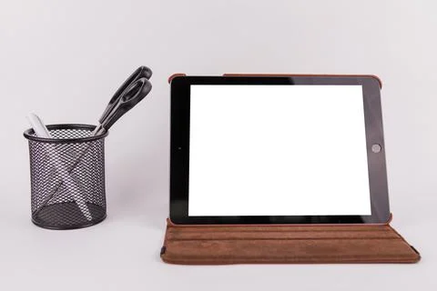 Tablet with white screen on table in office on white background Stock Photos