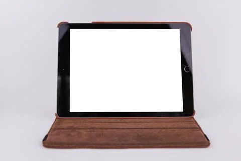 Tablet with white screen on table in office on white background Stock Photos