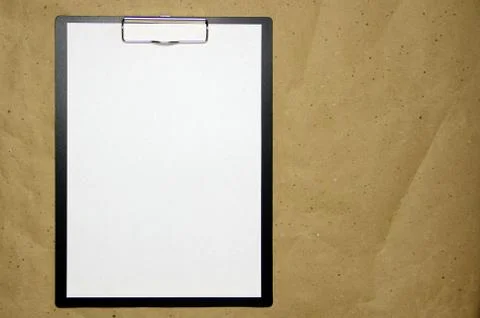 A tablet with a white sheet of A4 format on a beige craft paper. Stock Photos