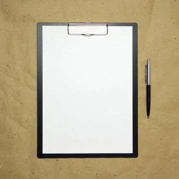 A tablet with a white sheet of A4 format on a beige craft paper. Stock Photos