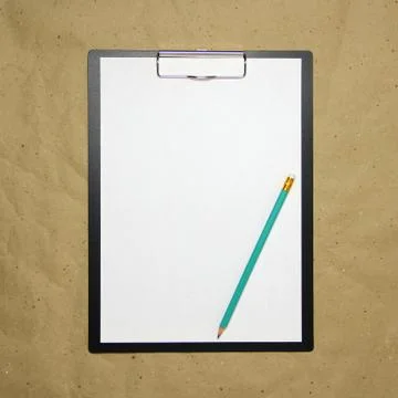 A tablet with a white sheet of A4 format on a beige craft paper. Stock Photos