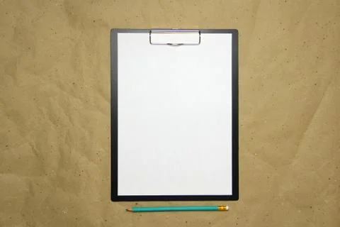 A tablet with a white sheet of A4 format on a beige craft paper. Stock Photos