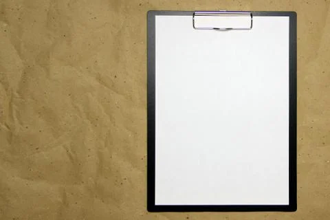 A tablet with a white sheet of A4 format on a beige craft paper. Stock Photos