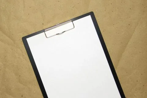 A tablet with a white sheet of A4 format on a beige craft paper. Stock Photos