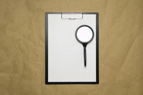 A tablet with a white sheet of A4 format on a beige craft paper. Stock Photos