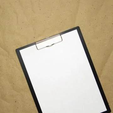 A tablet with a white sheet of A4 format on a beige craft paper. Stock Photos