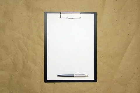 A tablet with a white sheet of A4 format on a beige craft paper. Stock Photos