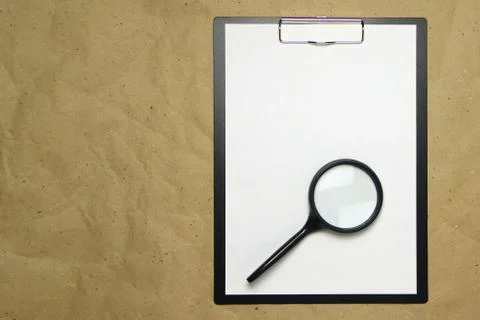 A tablet with a white sheet of A4 format on a beige craft paper. Stock Photos
