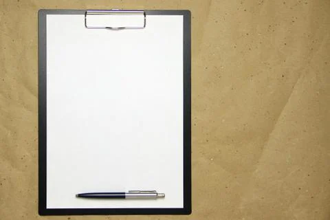 A tablet with a white sheet of A4 format on a beige craft paper. Stock Photos