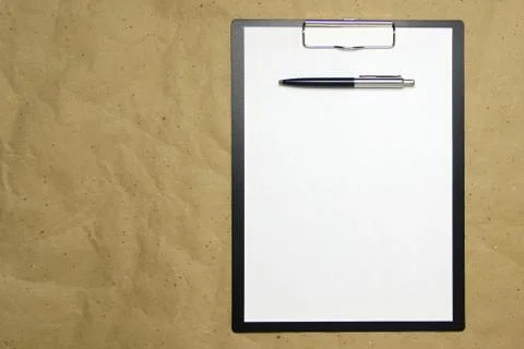 A tablet with a white sheet of A4 format on a beige craft paper. Stock Photos