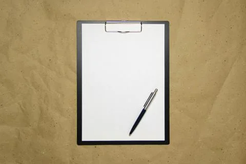 A tablet with a white sheet of A4 format on a beige craft paper. Stock Photos