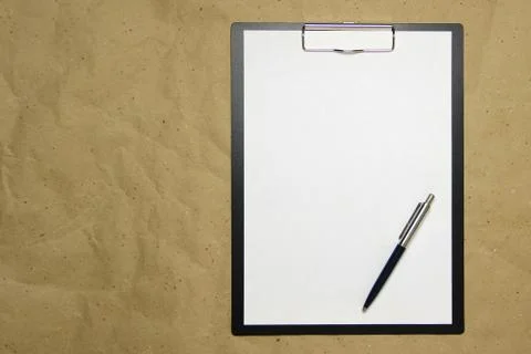 A tablet with a white sheet of A4 format on a beige craft paper. Stock Photos