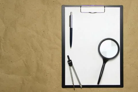 A tablet with a white sheet of A4 format on a beige craft paper. Stock Photos