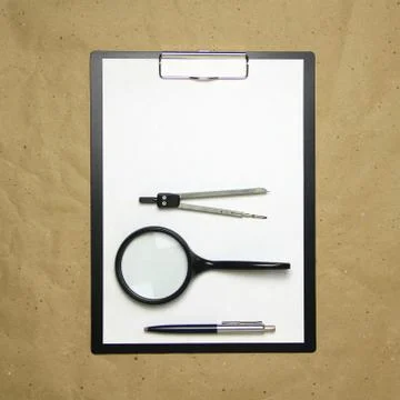 A tablet with a white sheet of A4 format on a beige craft paper. Stock Photos