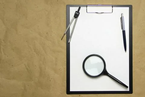 A tablet with a white sheet of A4 format on a beige craft paper. Stock Photos