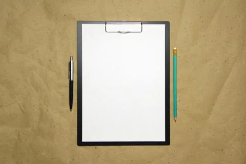 A tablet with a white sheet of A4 format on a beige craft paper. Stock Photos