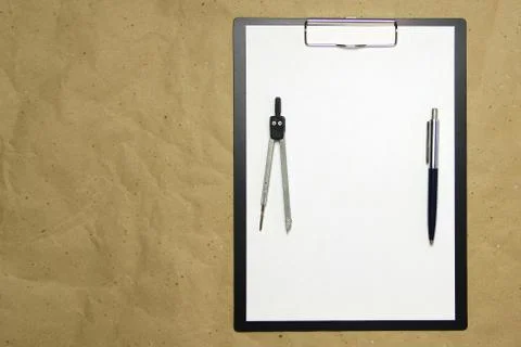A tablet with a white sheet of A4 format on a beige craft paper. Stock Photos