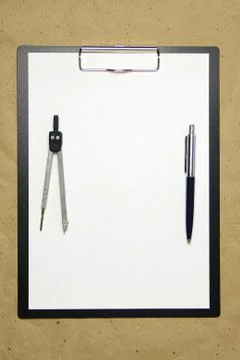 A tablet with a white sheet of A4 format on a beige craft paper. Stock Photos