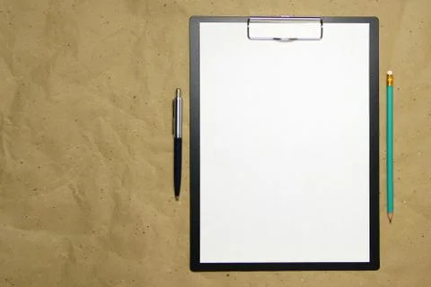 A tablet with a white sheet of A4 format on a beige craft paper. Stock Photos