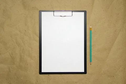 A tablet with a white sheet of A4 format on a beige craft paper. Stock Photos