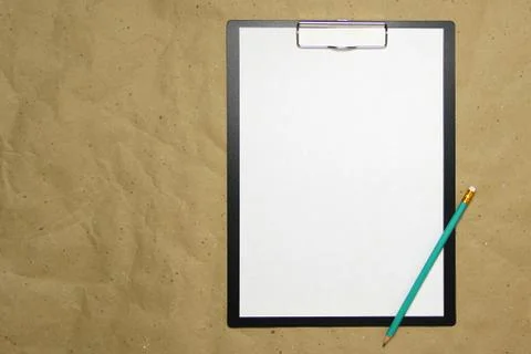 A tablet with a white sheet of A4 format on a beige craft paper. Stock Photos