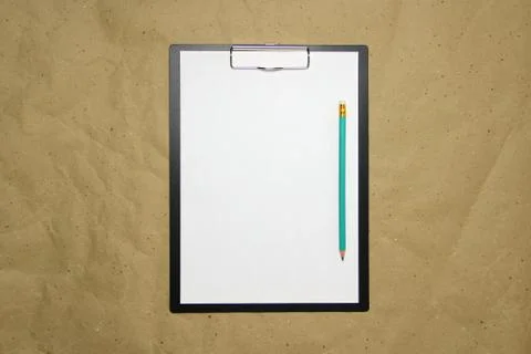 A tablet with a white sheet of A4 format on a beige craft paper. Stock Photos