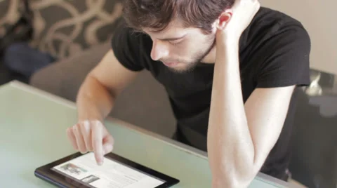 Tablet -  young male in thoughts doing an exam Stock Footage 32354844