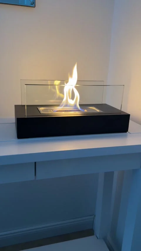 Tabletop bioethanol fireplace burning on a white console table close up 4K Stock-Footage 345754586