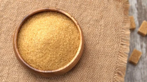 Tabletop of brown sugar rotating on burlap. Four lumps of brown sugar on rustic Stock Footage 69982184