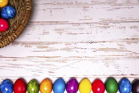 Tabletop easter theme with copy space. Colorful easter eggs with basket Stock Photos
