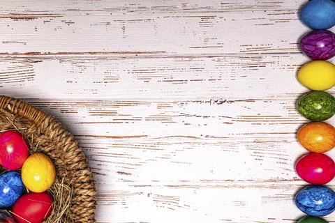 Tabletop easter theme with copy space. Colorful easter eggs with basket Stock Photos