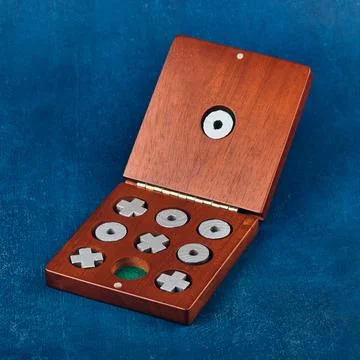 Tabletop Game of Tic Tac Toe in a wooden box on a blue background, shallow de Stock Photos